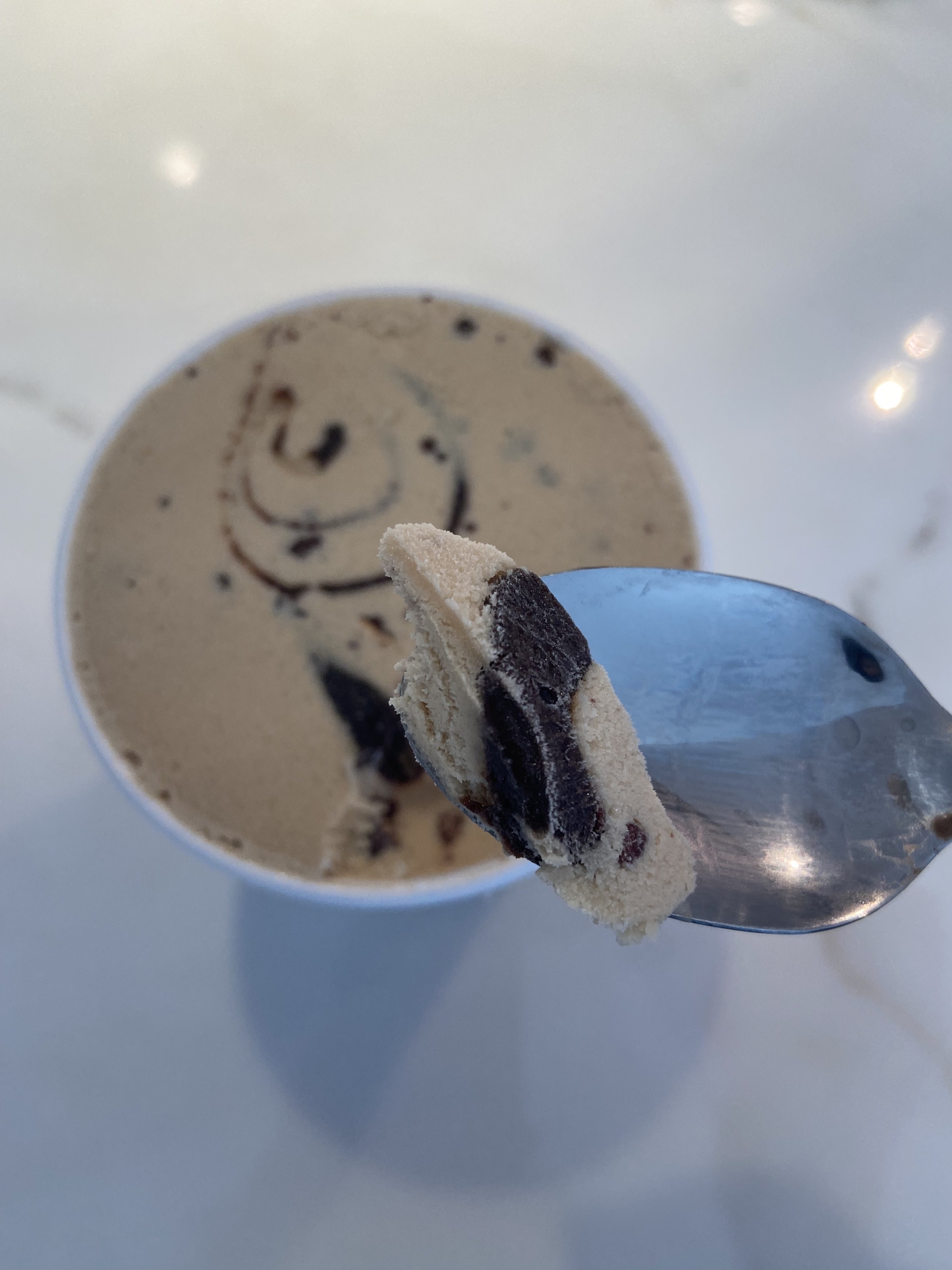 The swirl is more prominent in this ice cream, and a spoonful of it shows it having layers of chocolate and fudge