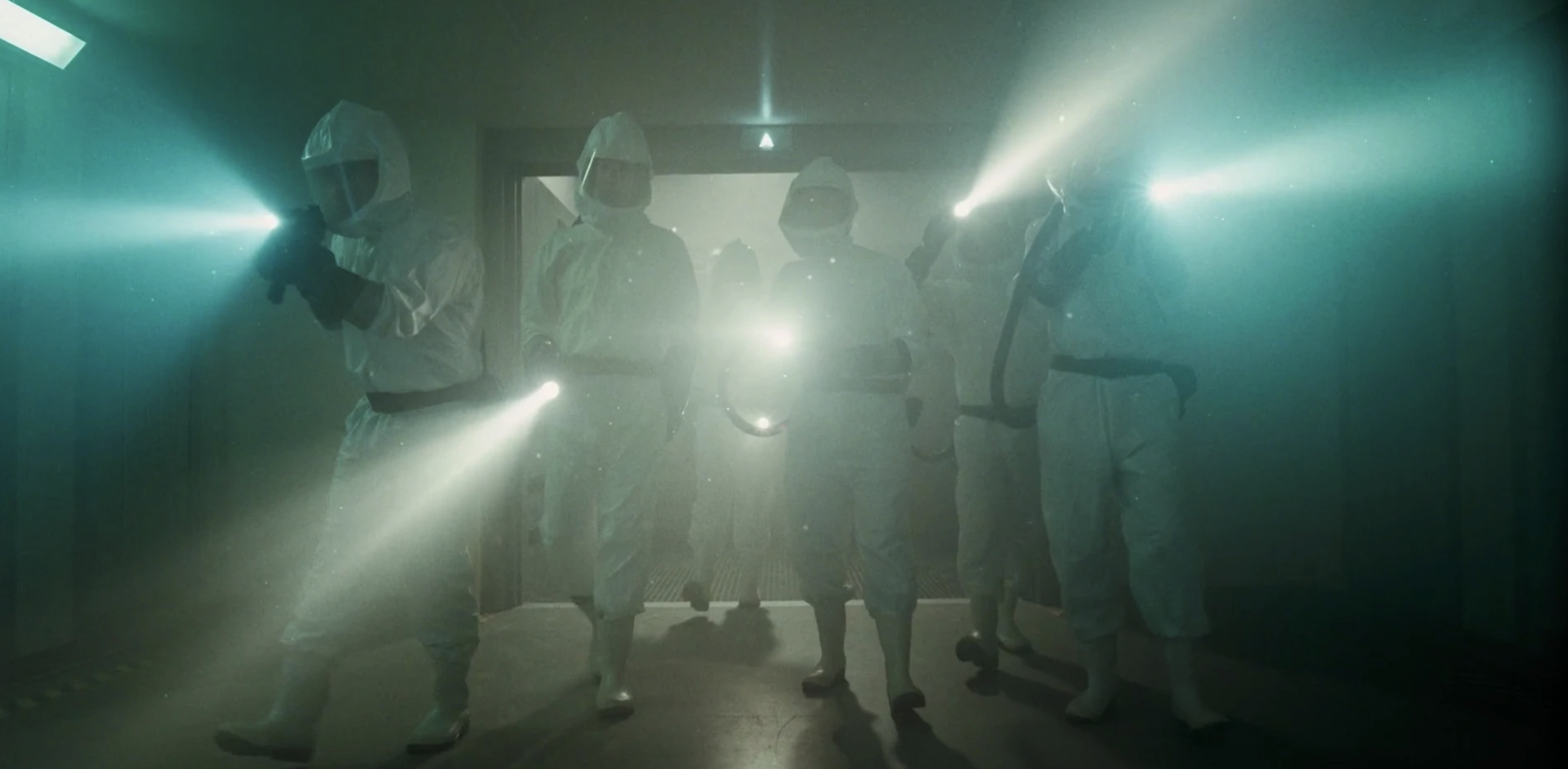 People in hazmat suits and flashlights
