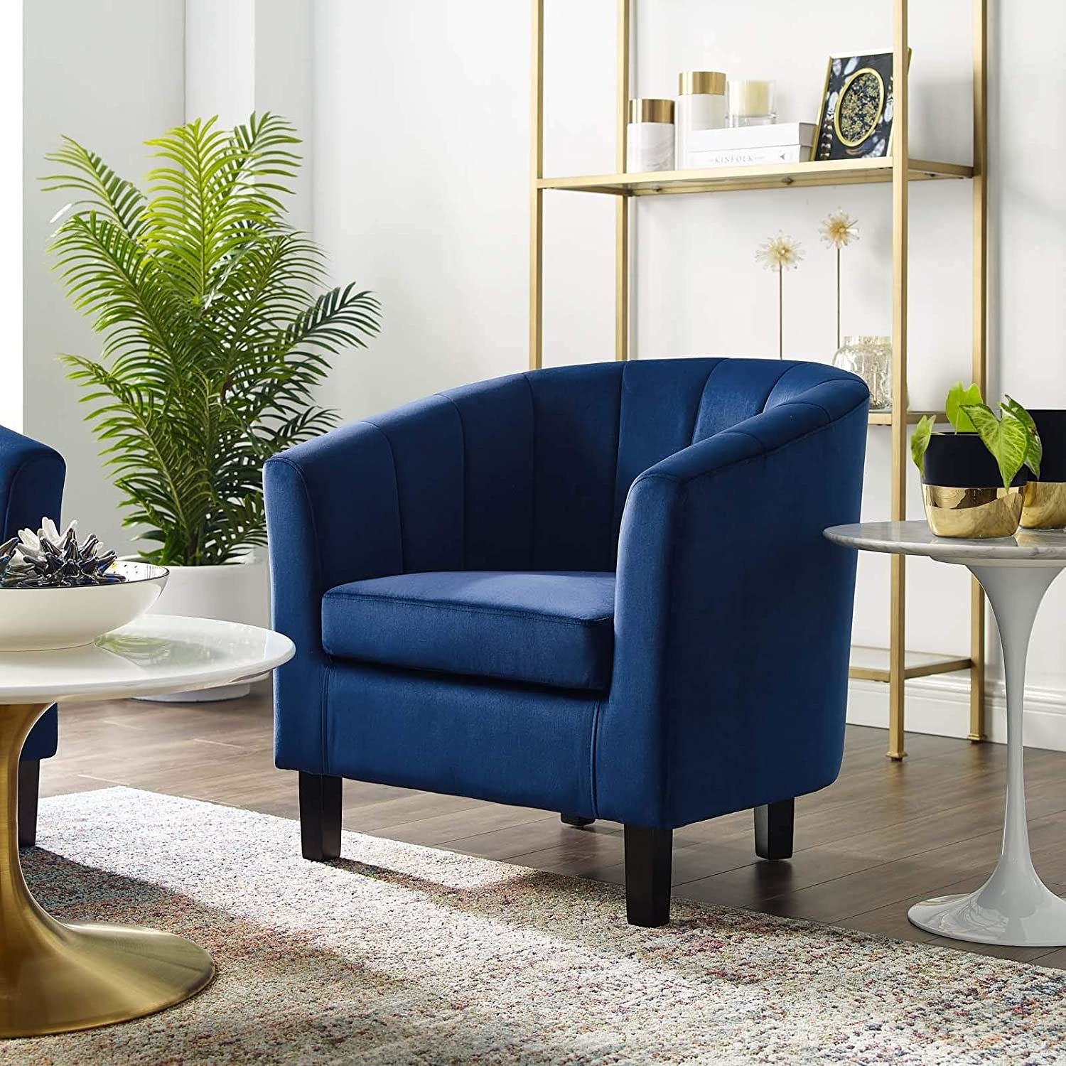 one navy tufted armchair in a living room