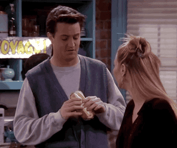 chandler and phoebe from friends sharing a sandwich