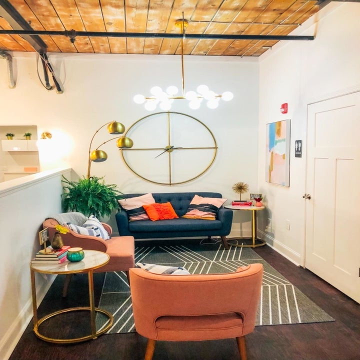 Eclectic entryway with a sofa, a pair of loveseats, and the 14-bulb modern chandelier hanging from the ceiling