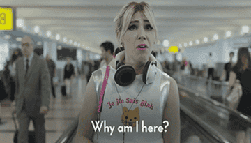 gif of shoshana from the hbo show girls in an airport saying, &quot;why am i here?&quot;