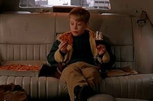Kevin McAllister sits in the back of a limo drinking soda in a wine glass and eating pizza