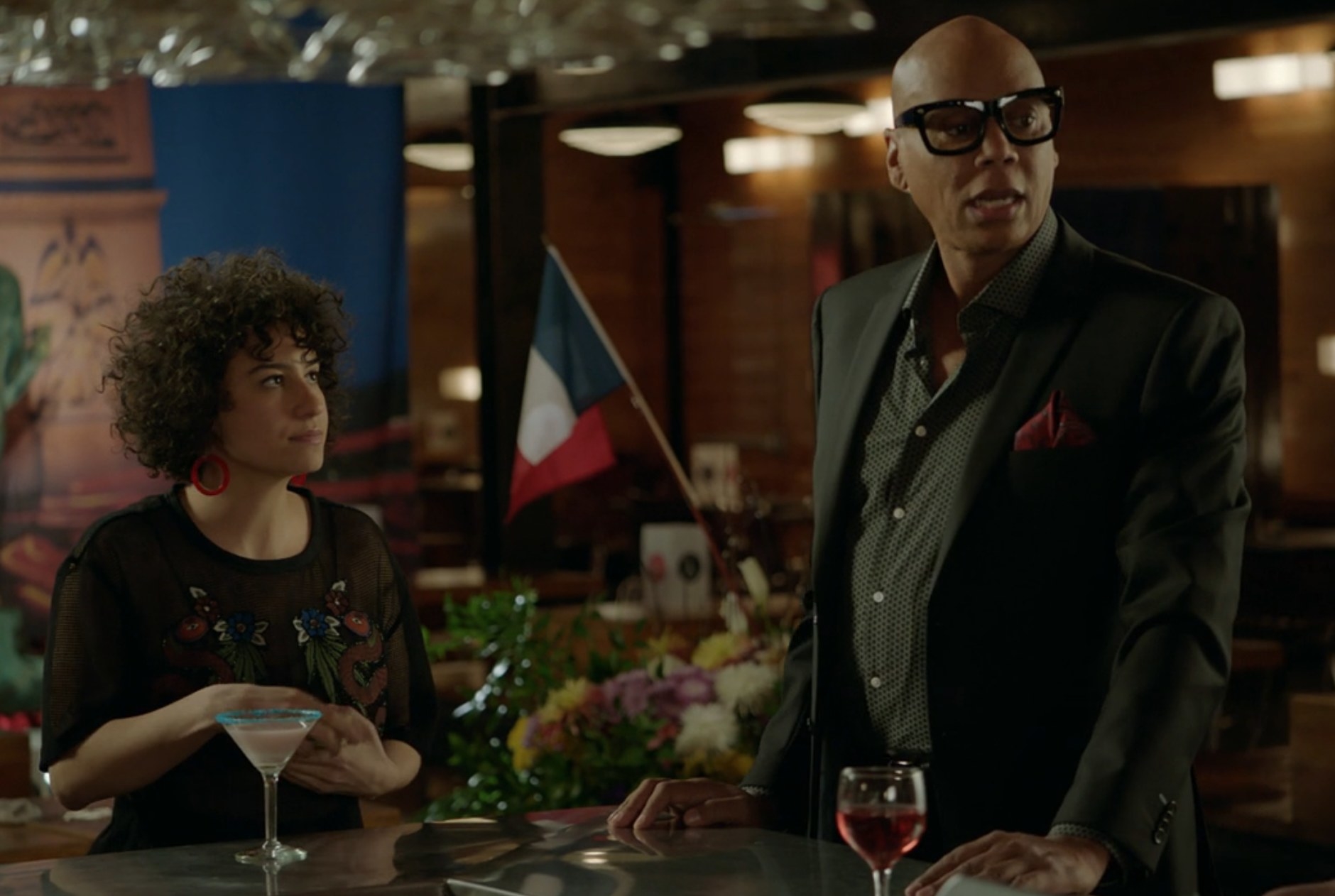 Ilana Glazer as Ilana Wexler and RuPaul as Marcel chat with some coworkers in &quot;Broad City&quot;