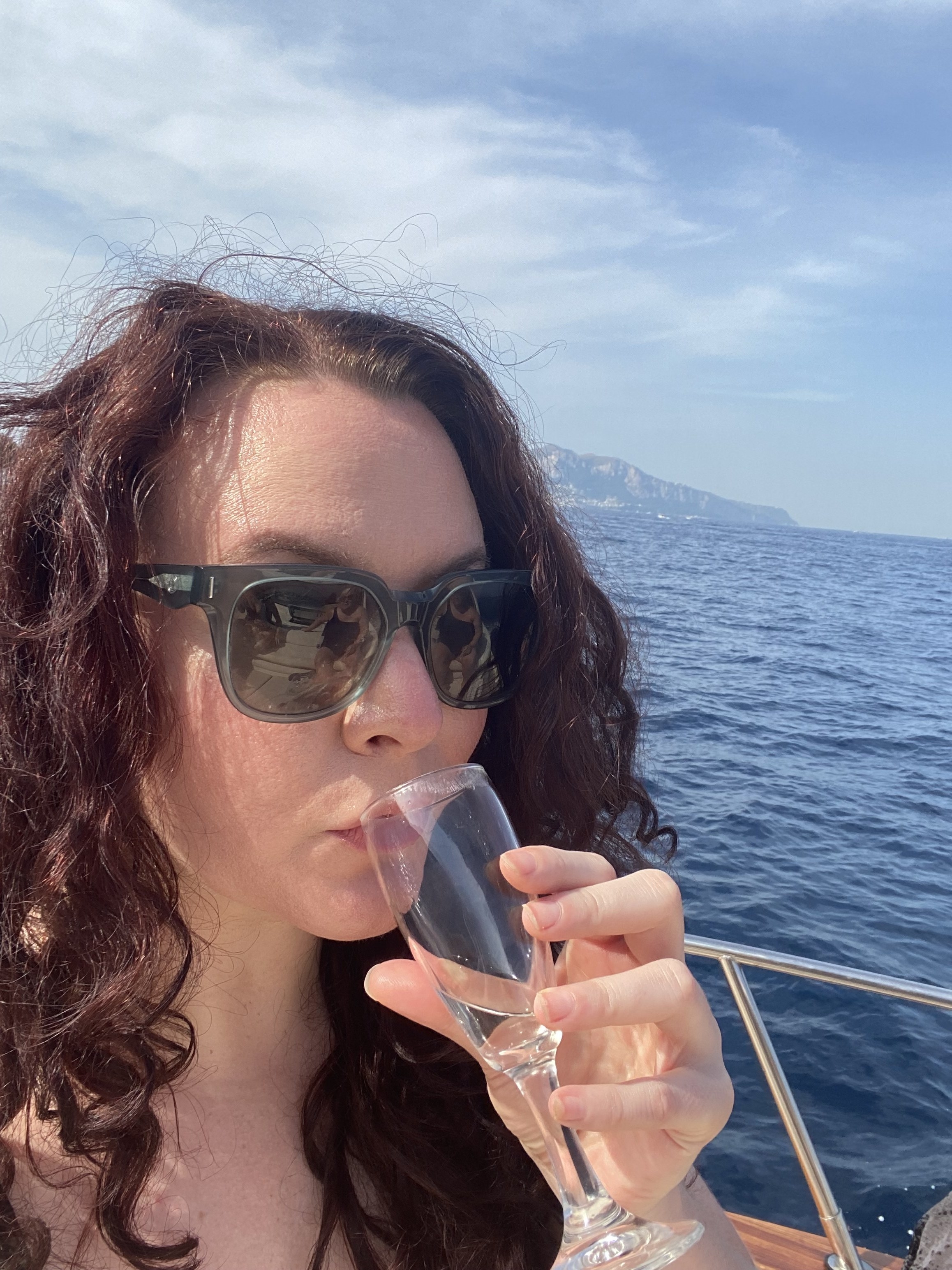 writer with curly hair on a boat