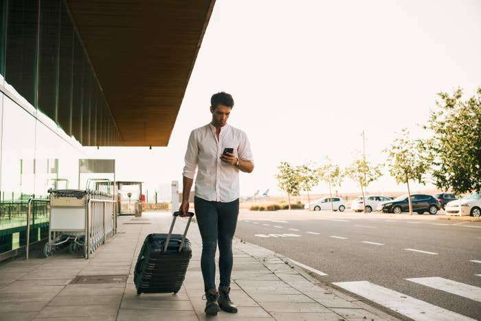 Man walking with suitcase outside airport