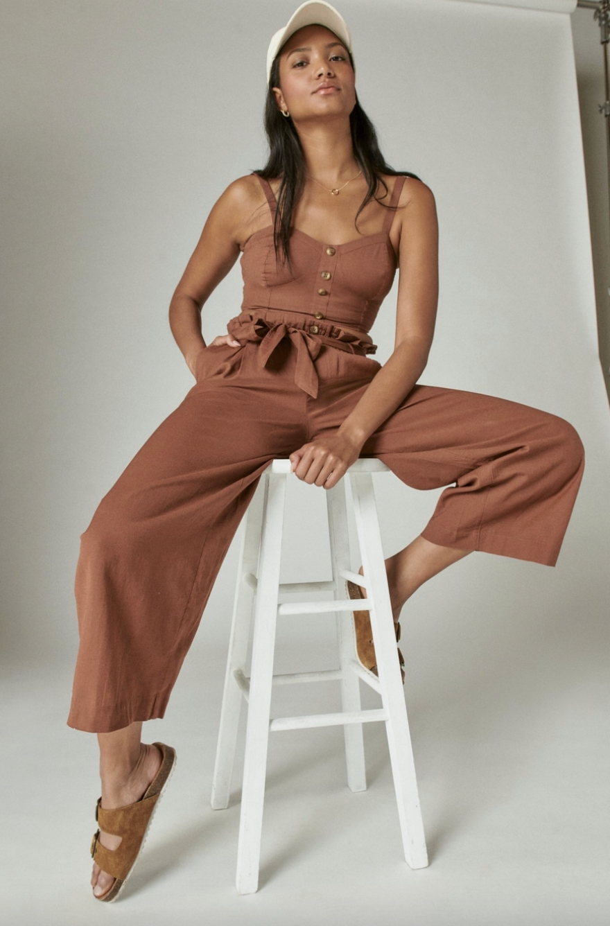 model wearing paper bag pants while sitting on stool