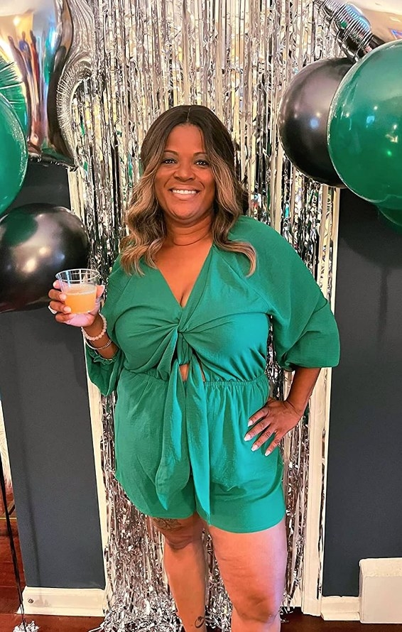 A reviewer wearing a green front tie romper