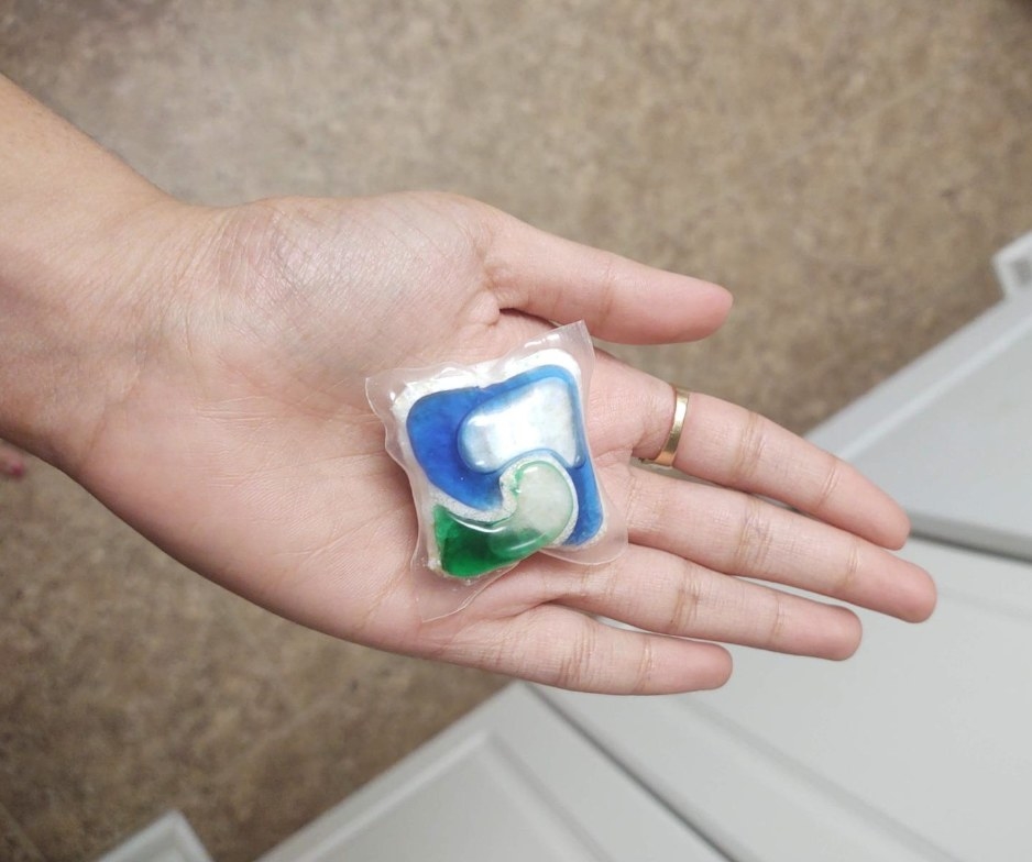 A reviewer&#x27;s photo of them holding a white, green and blue pod