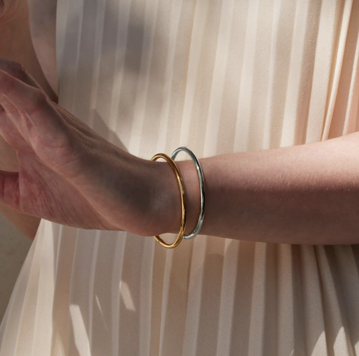 a person wearing the two-tone bangles on their wrist