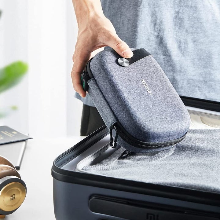 person putting the pack into their suit case