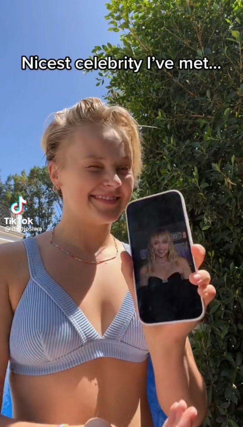JoJo holds up her phone with a photo of Miley Cyrus