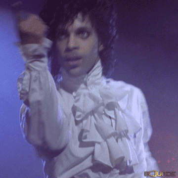 Prince in a white shirt and smoothing his hair