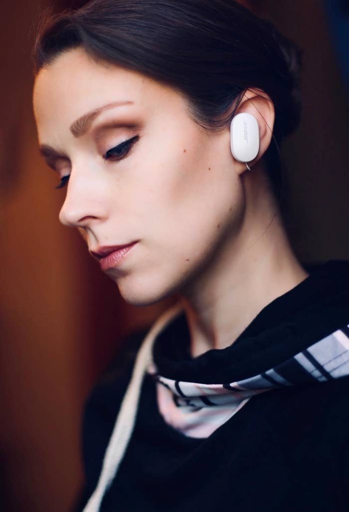 Model sitting outside with the black earbud in ear