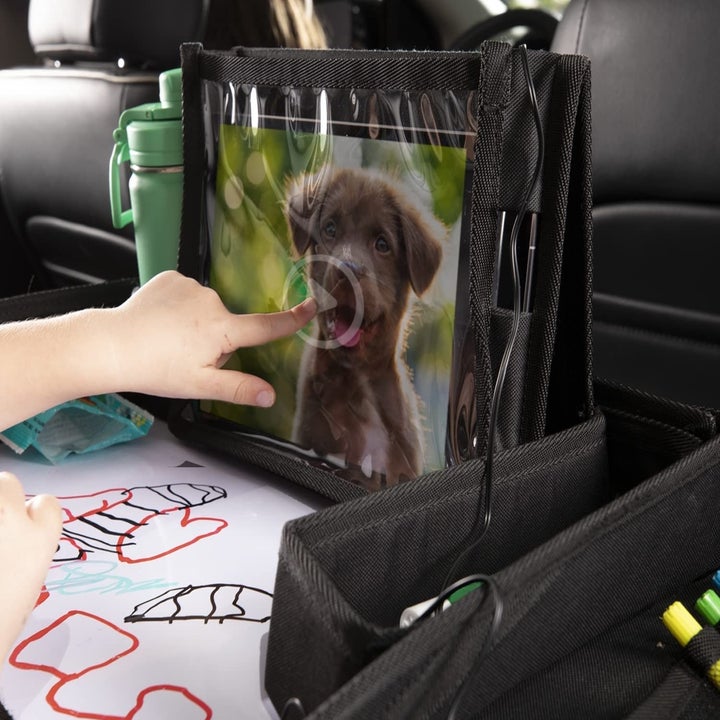 child using an ipad that is enclosed in the case on the tray