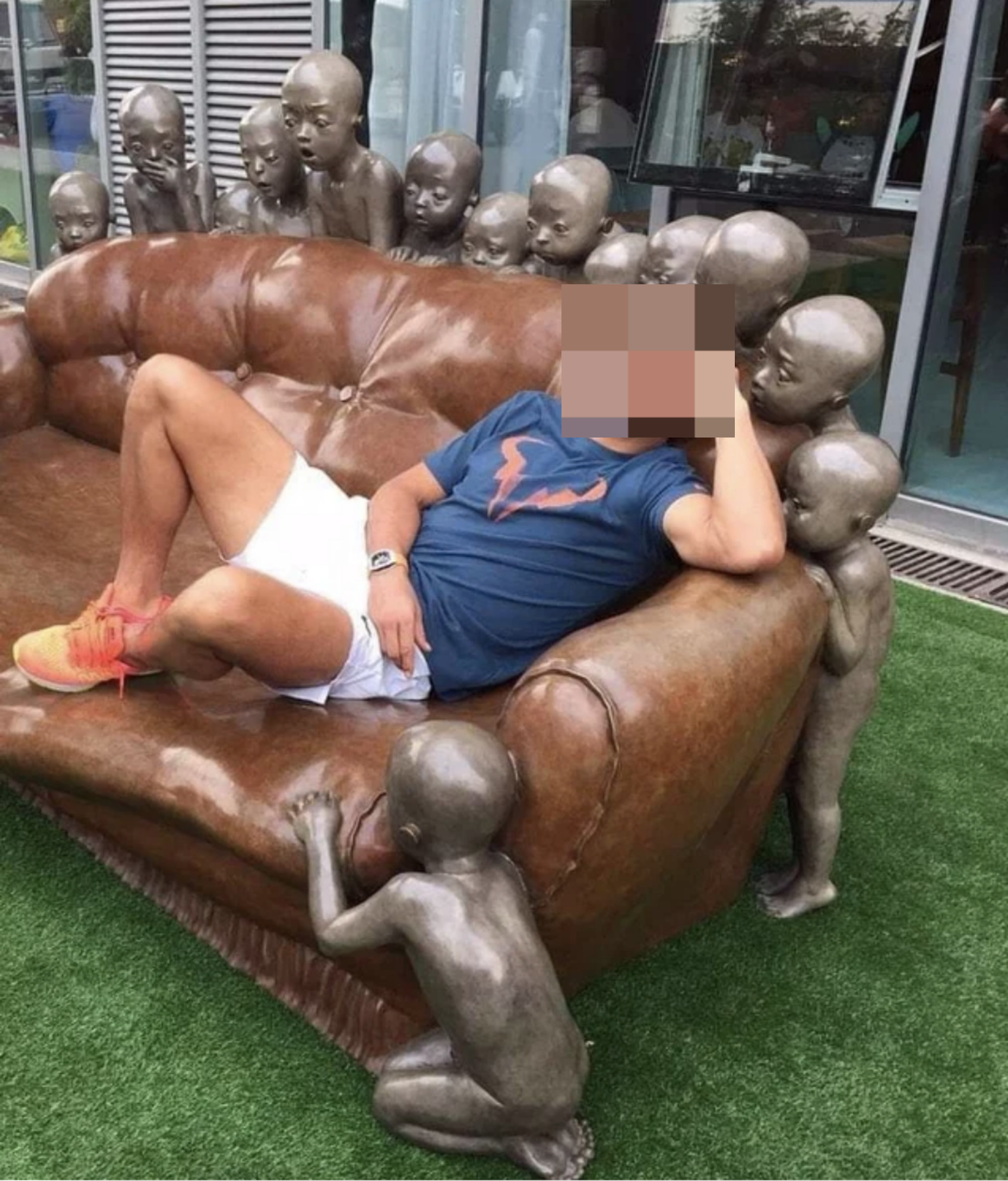 couch with naked children statues hovering around it