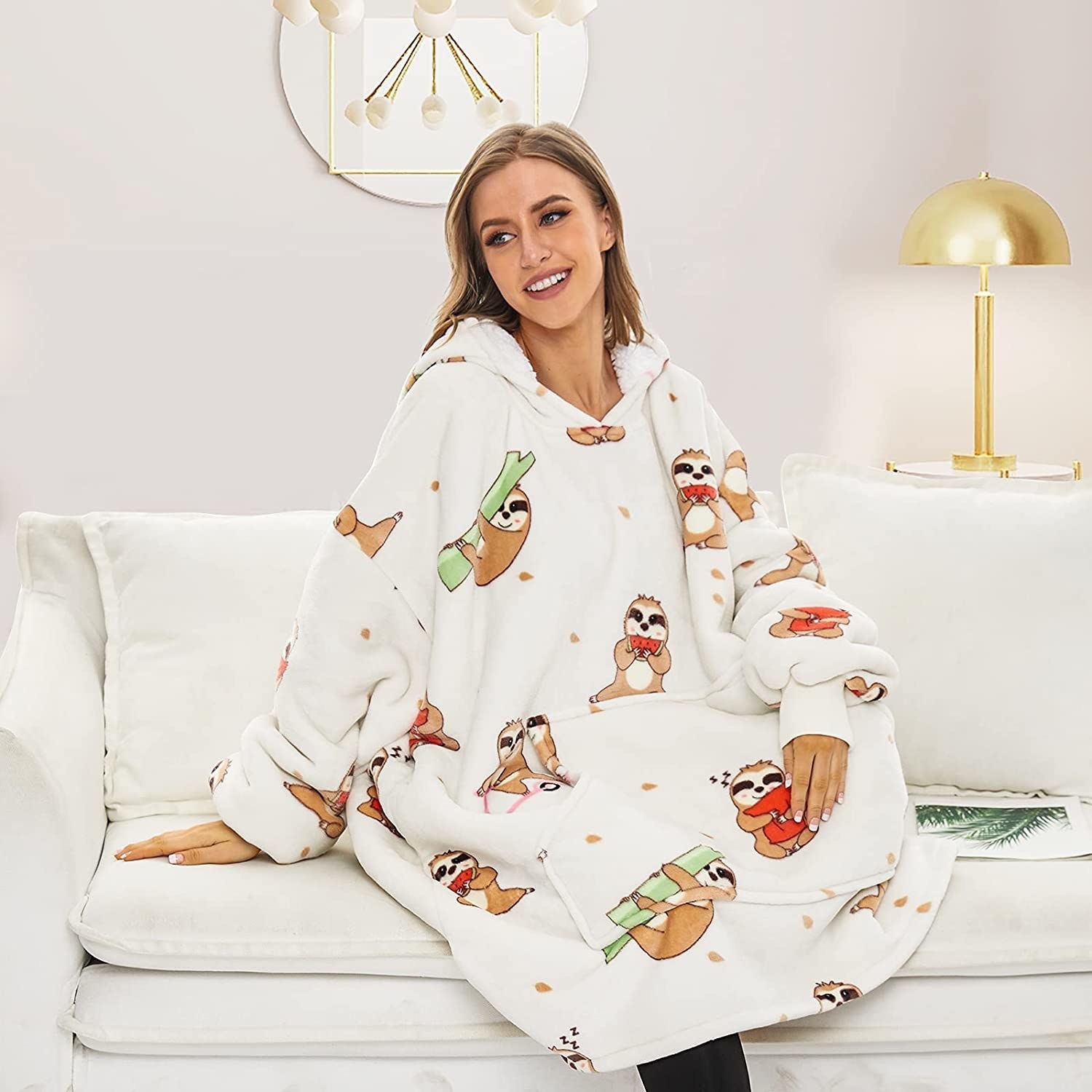 A person wearing the hoodie blanket on a couch
