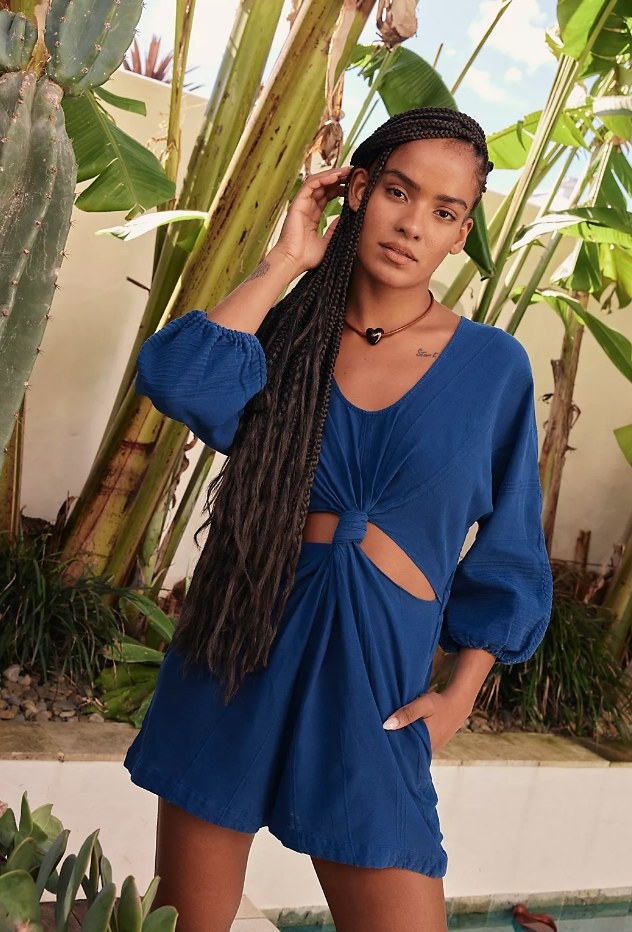 A model wearing a deep blue knotted romper