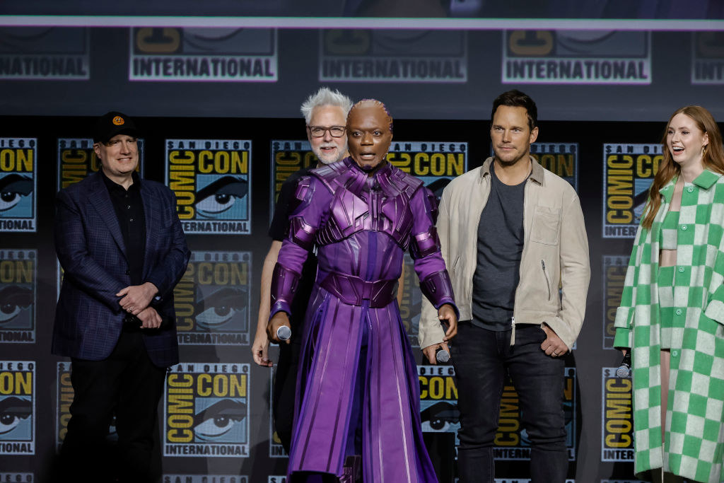 Chukwudi makes his way on stage while in full costume, while Kevin Feige, James Gunn, and Karen Gillan smile behind him