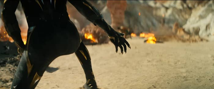 A still from the trailer that shows someone in the Black Panther suit extend its claws, but the face of the person wearing the suit is not visible