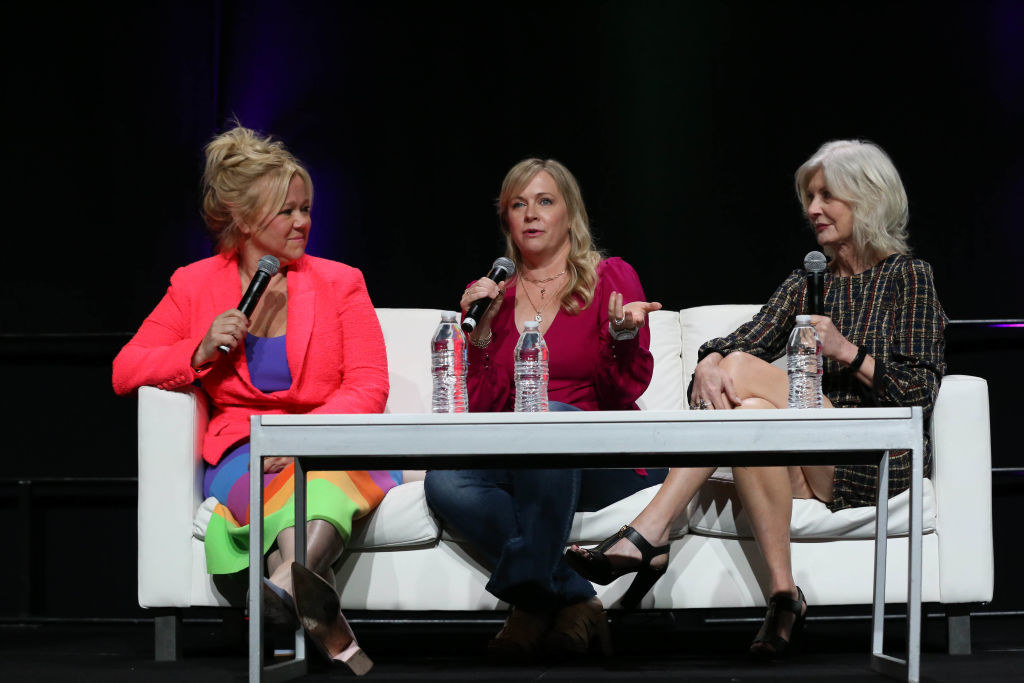 the three women sitting on a couch with mics