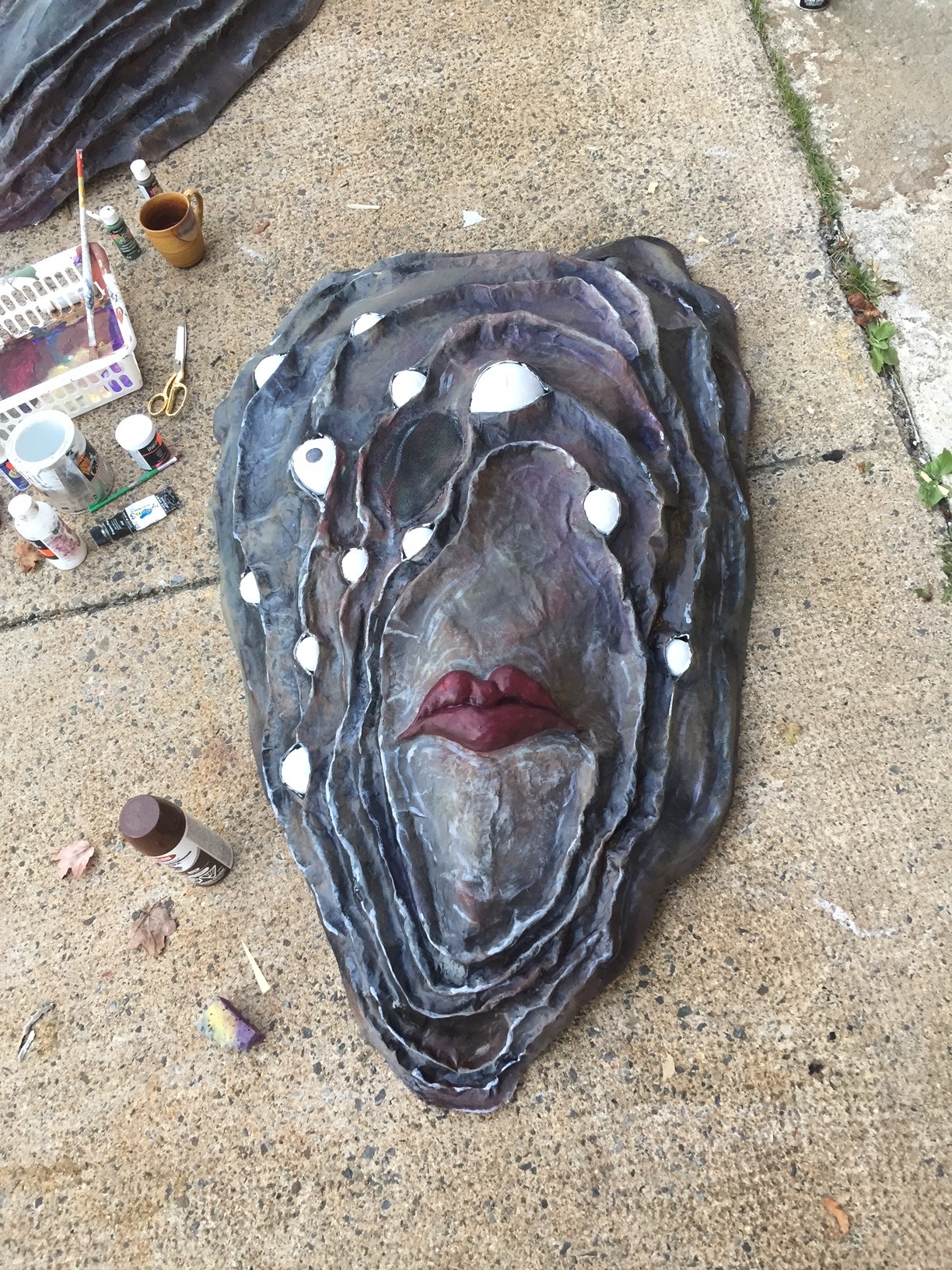 The lifeless oyster costume sits incomplete on the floor as its eyes are painted on
