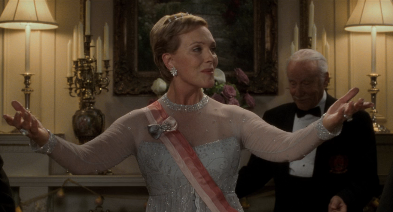 the queen entering the room in a sparkling gown
