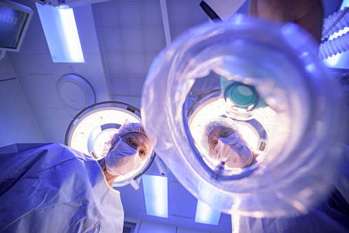 Doctors looking down at a patient as they&#x27;re about to go under.