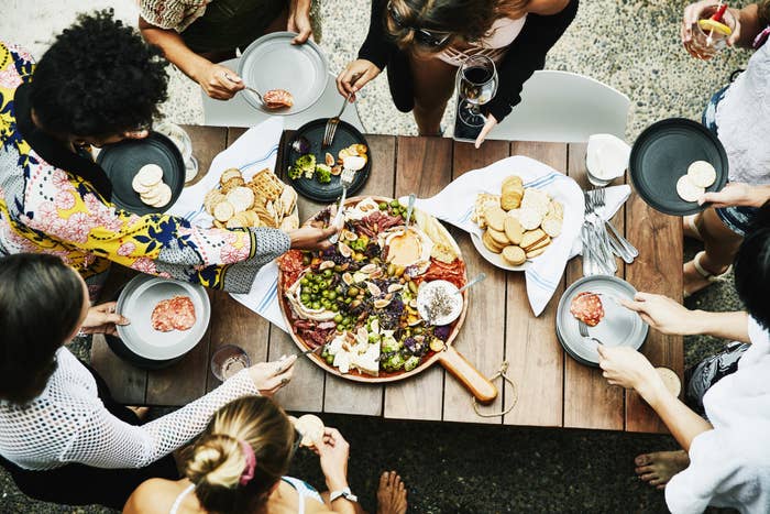 A group of friends sharing food from a huge spread