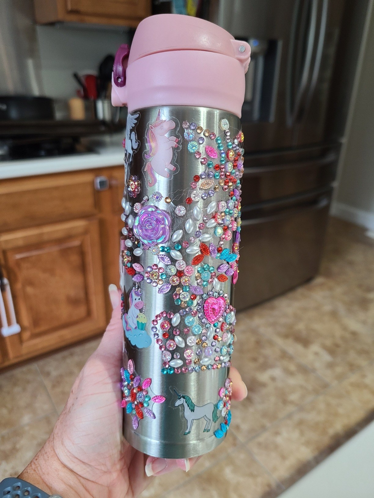 A reviewer holding their decorated water bottle