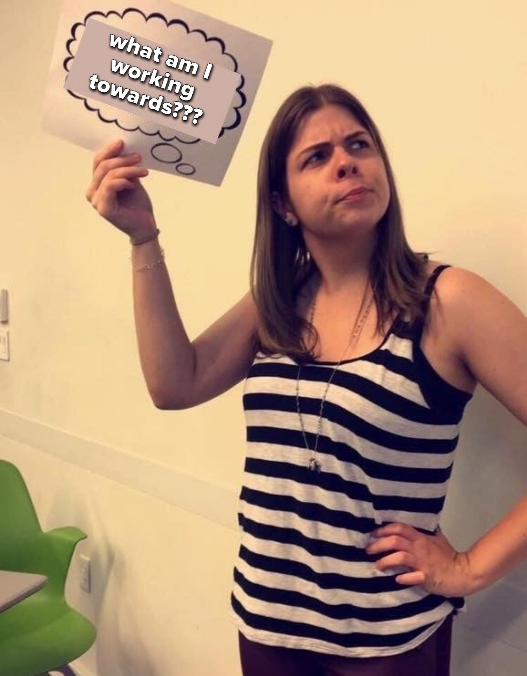 author holding up a sign that says, what am I working towards