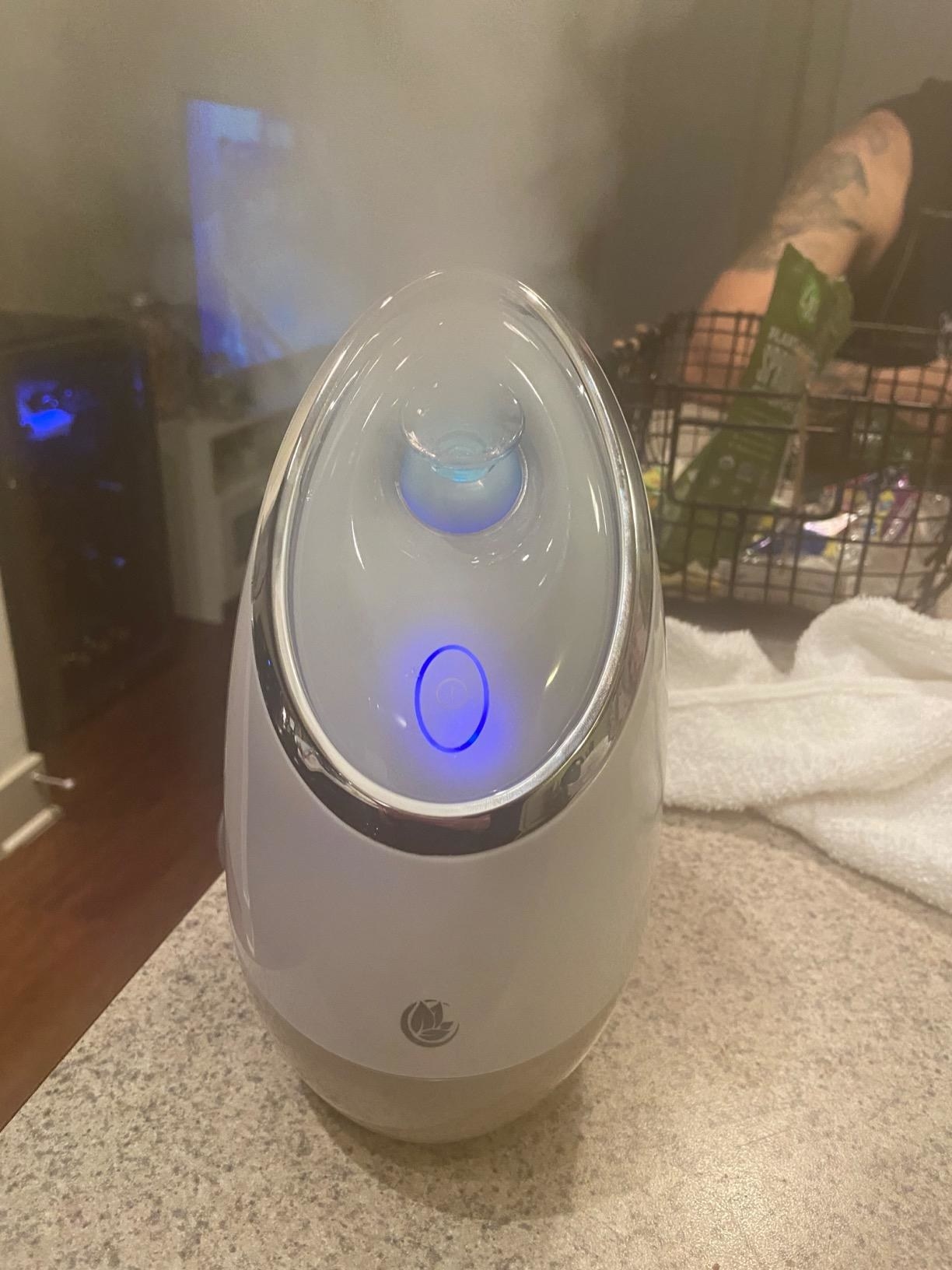 a reviewer photo of the facial steamer with steam coming out