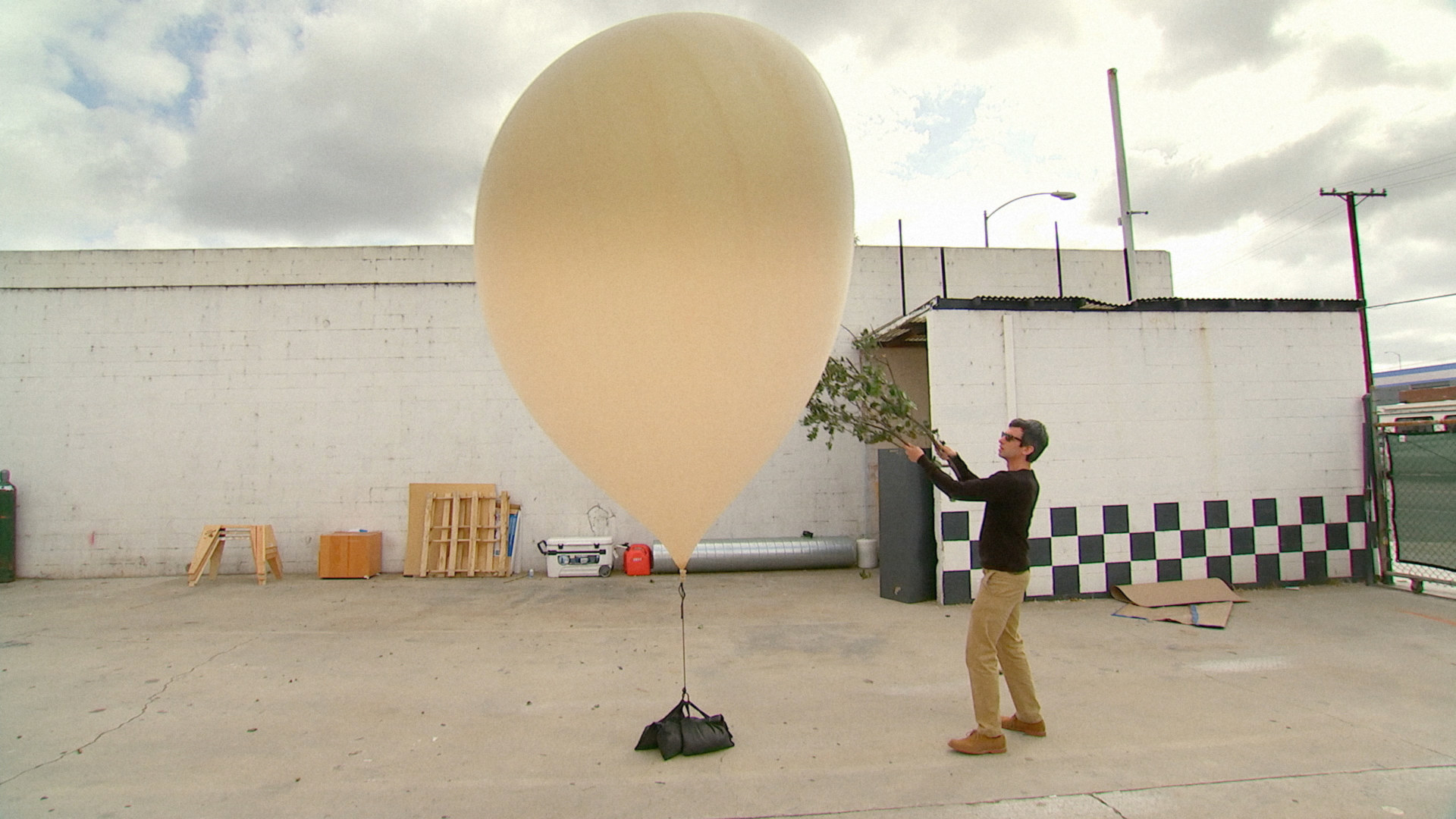 Nathan Field tests the durability of a massive helium balloon with a pair of branches.