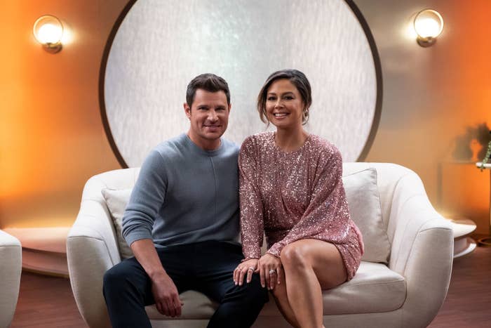 The couple sitting on a couch smiling for a photo