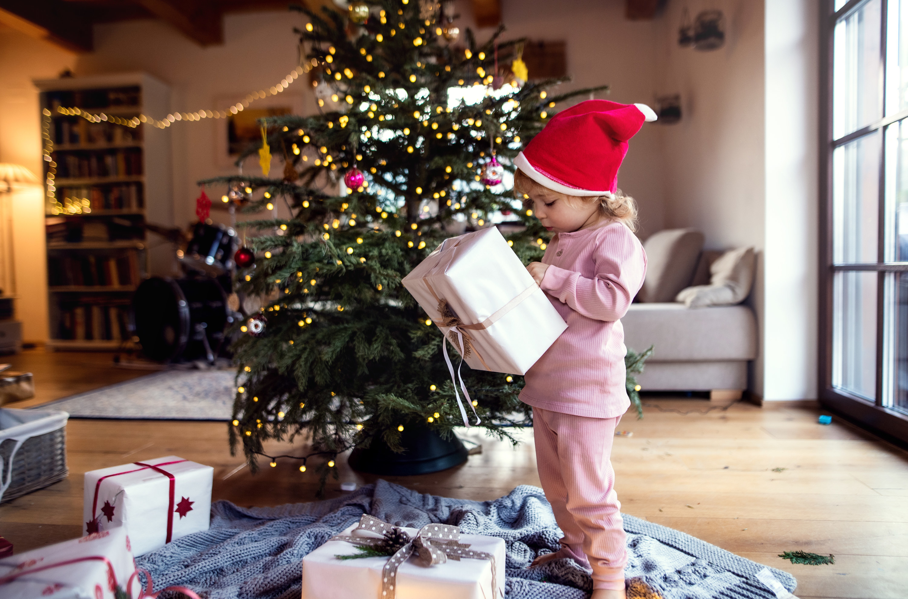 a little girl holding a gift on christmas