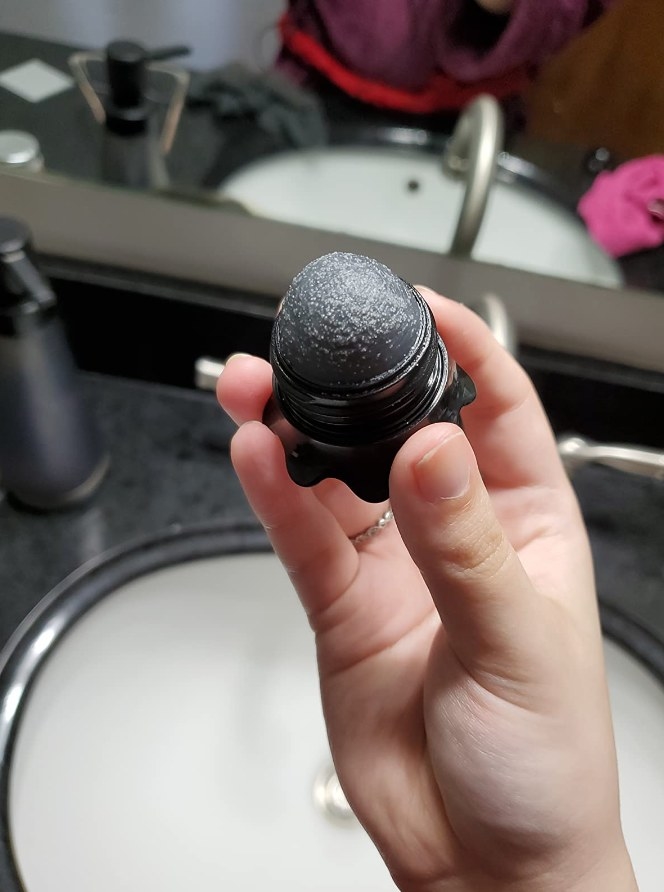 A reviewer&#x27;s photo of a black stick with a rough texture