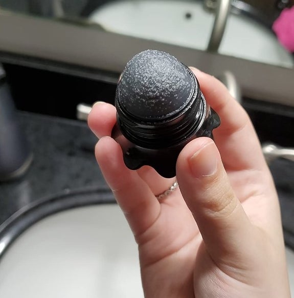 A reviewer's photo of a black stick with a rough texture