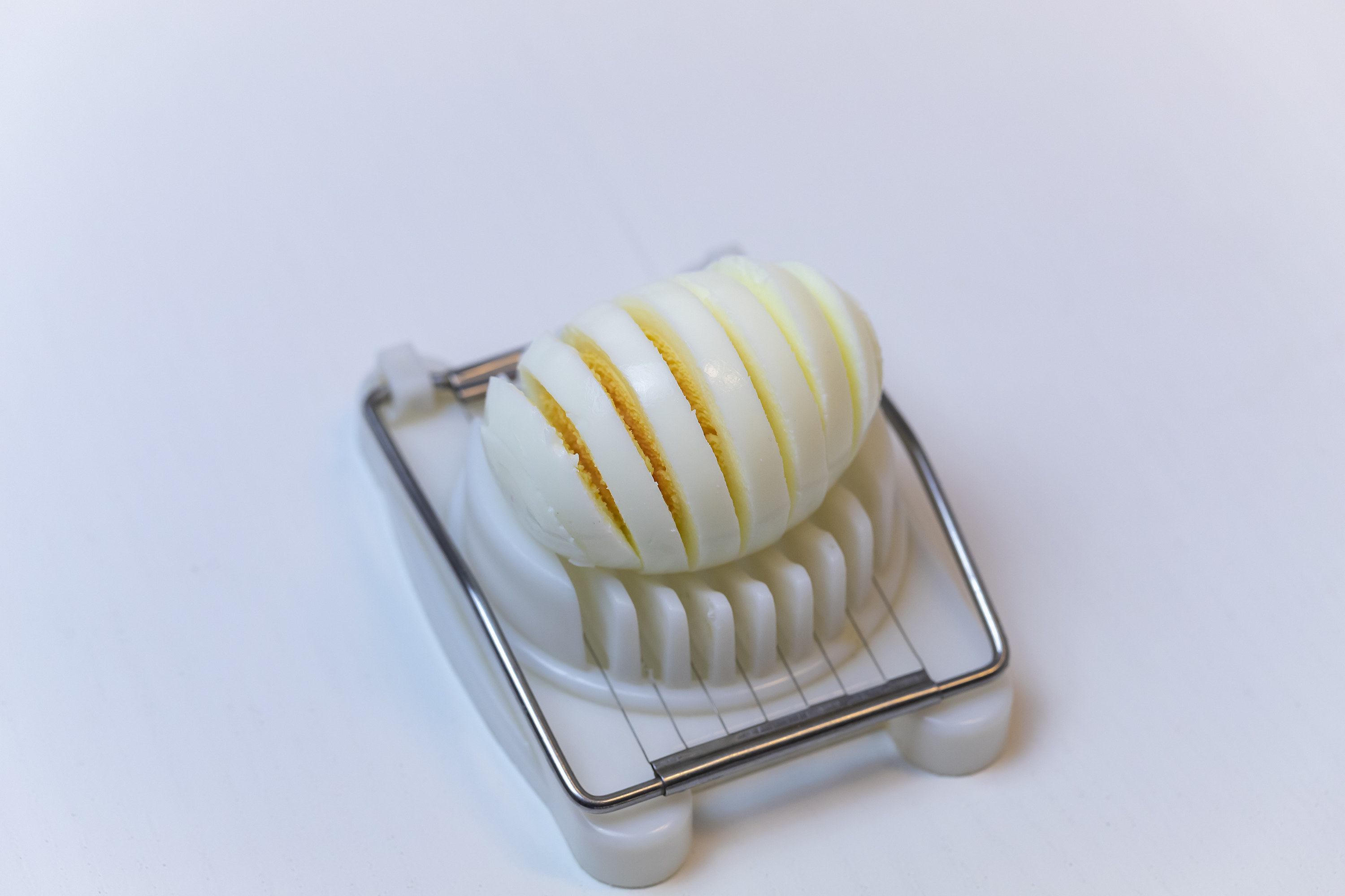 Egg sliced into even pieces using a plastic and metal egg slicer tool