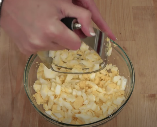 Chopping eggs with a pastry blender for egg salad