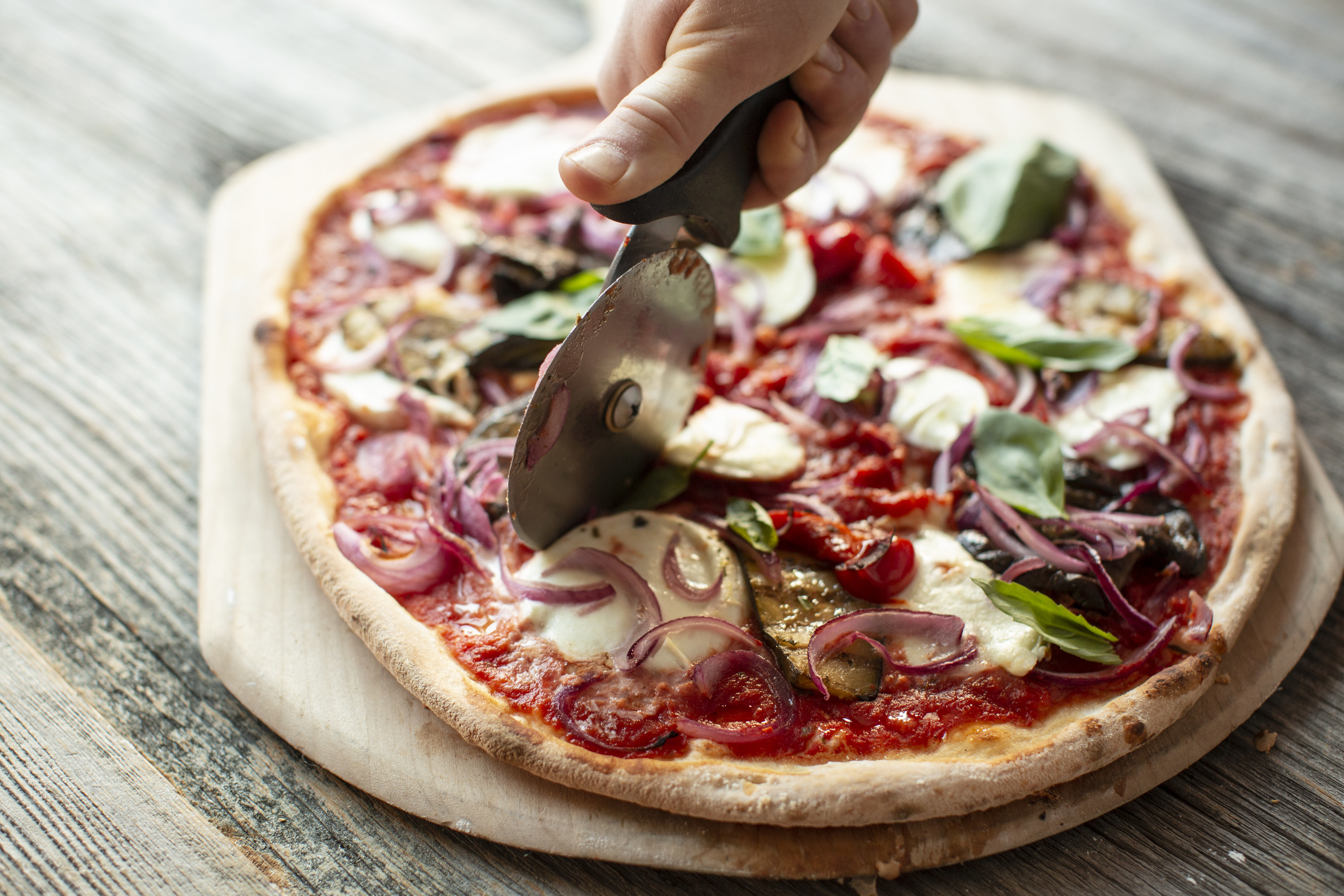 Slicing pizza with a pizza cutter