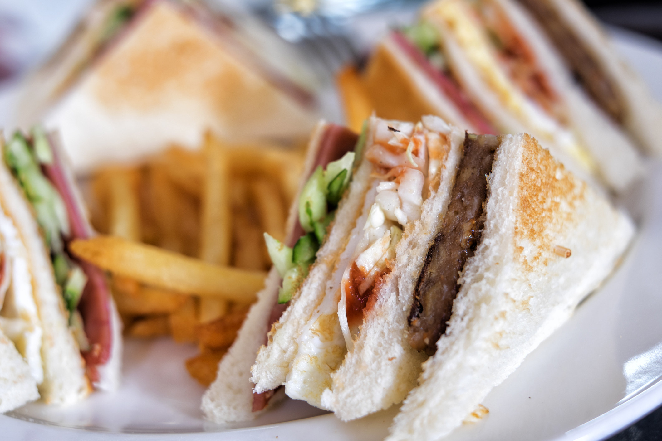 A club sandwich with fries.