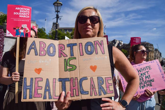 A woman at a protest holding a sign that says &quot;abortion is healthcare&quot;
