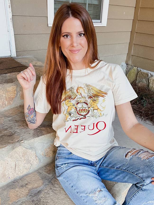 a reviewer poses in the beige Queen tee
