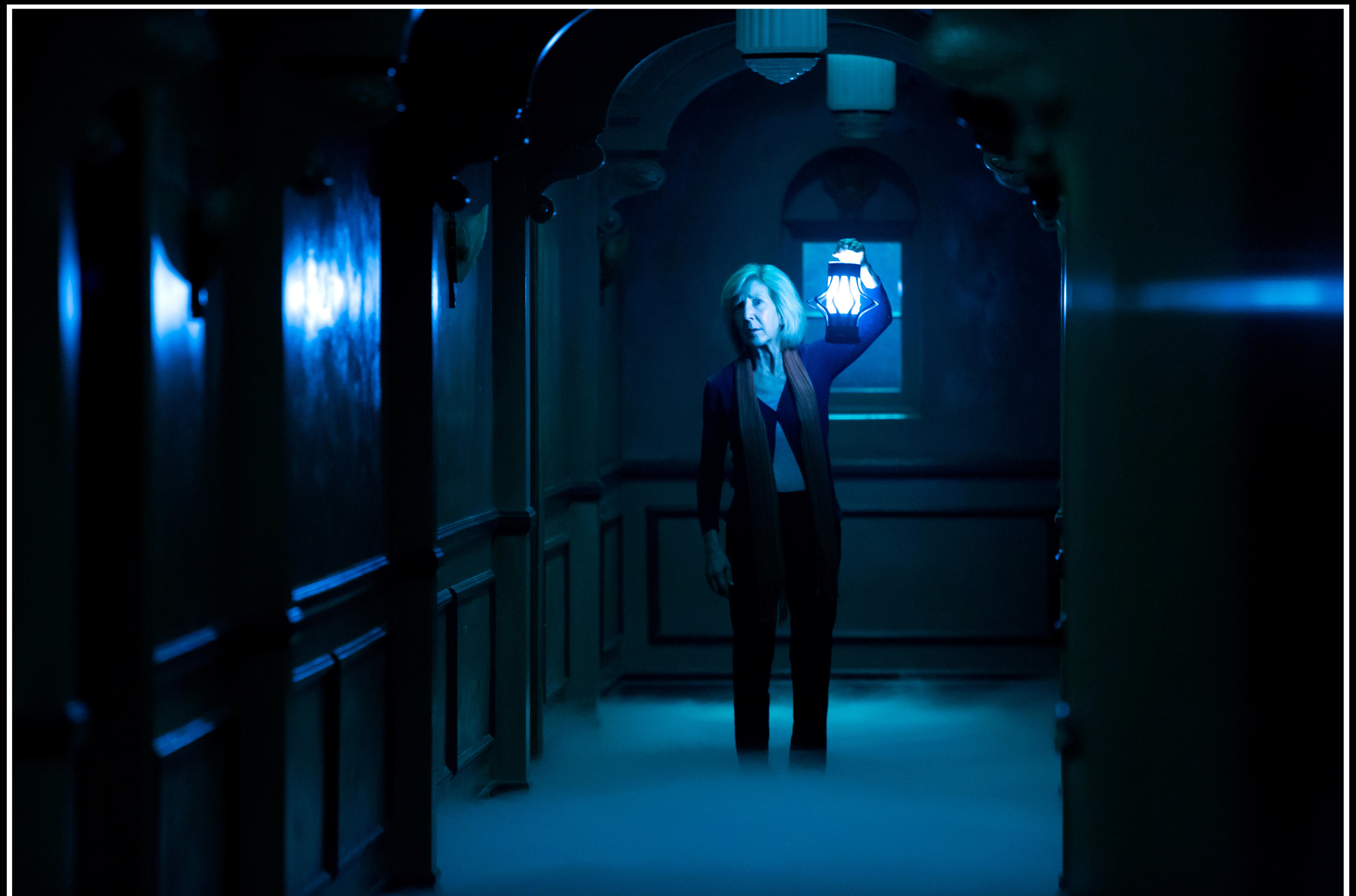 Lin Shaye raises a lantern in a foggy otherworldly hallway in &quot;Insidious: Chapter 3&quot;