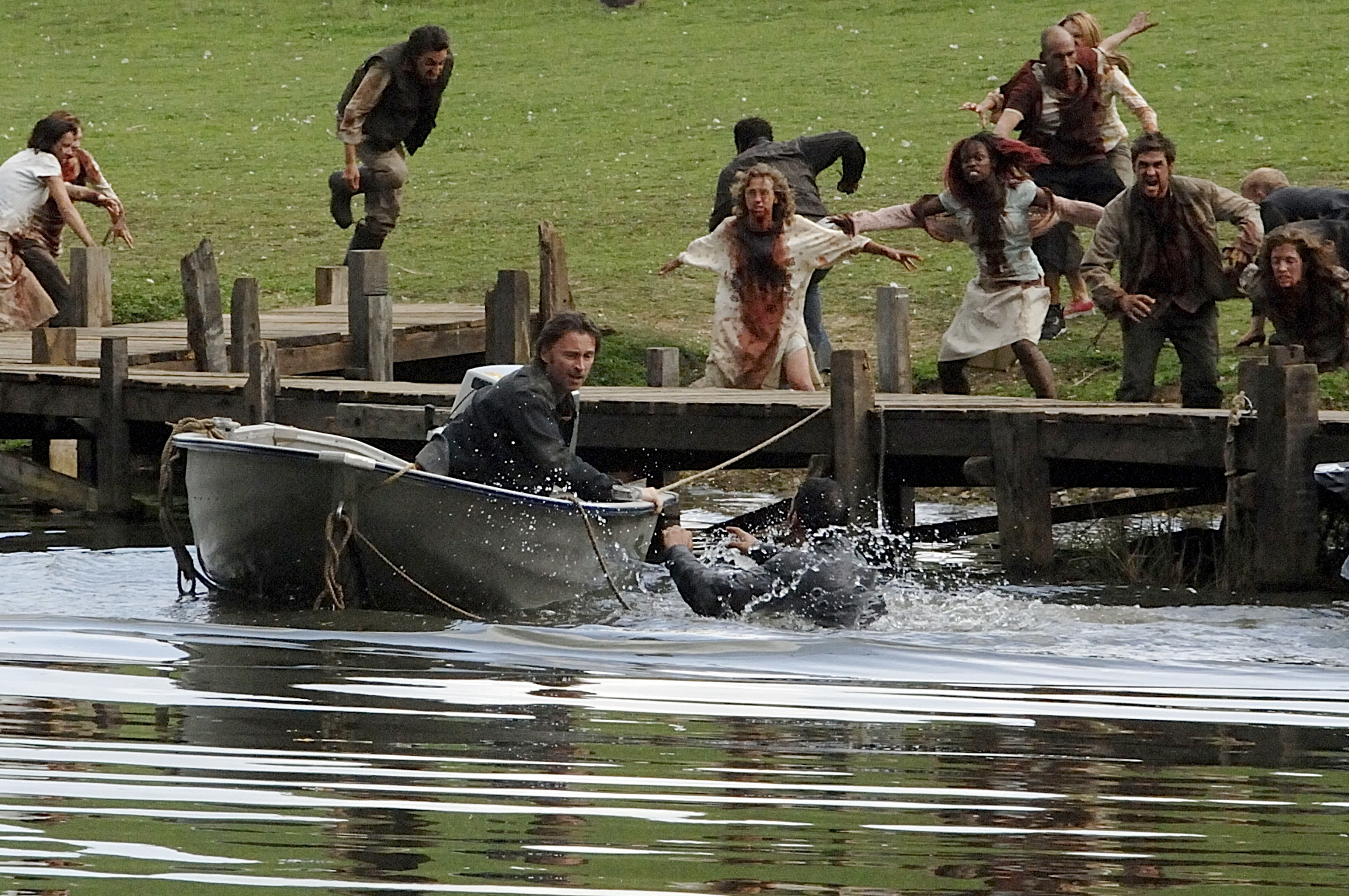 Robert Carlyle narrowly avoids rage-filled zombies descending upon him on a boat near a countryside lake in &quot;28 Weeks Later&quot;