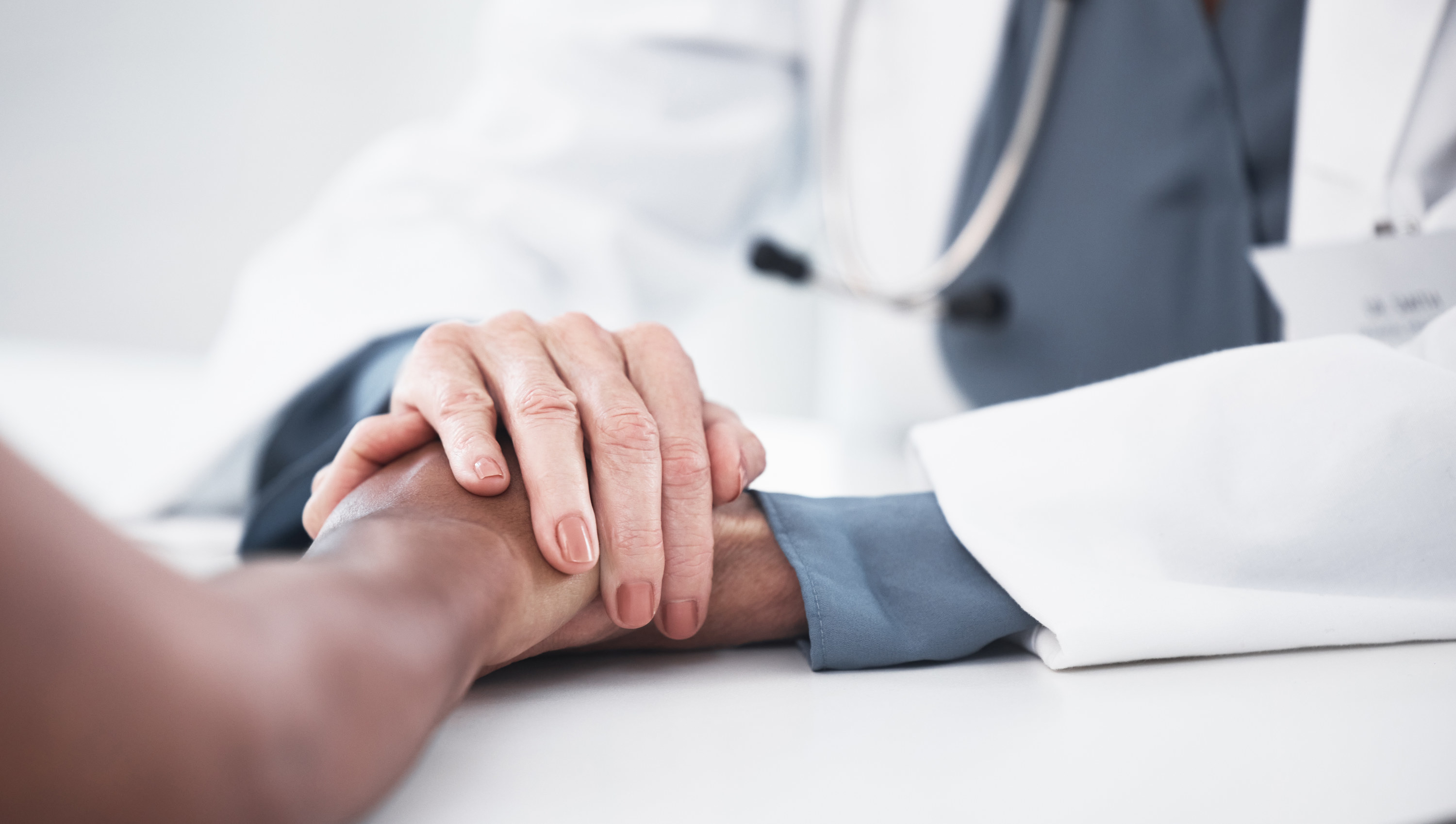 A doctor and patient holding hands