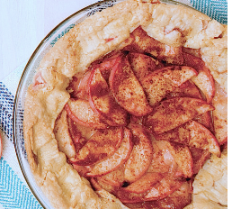 Round pastry with peach slices sprinkled with cinnamon