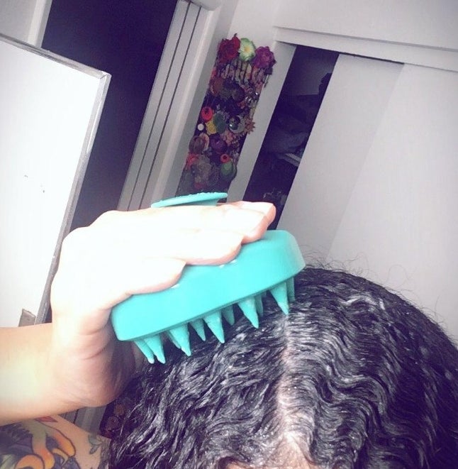 A reviewer with brown hair using aqua scalp massager