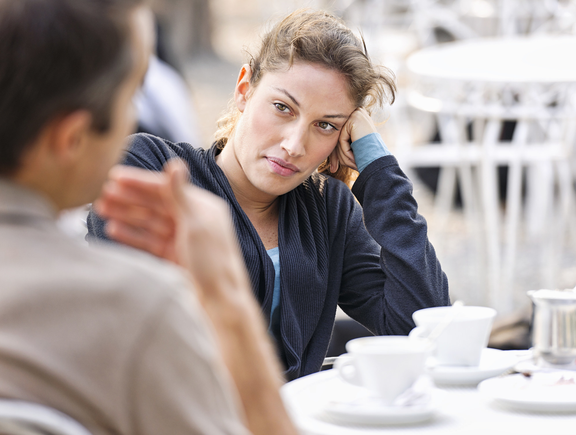 A woman looking bored while having a conversation
