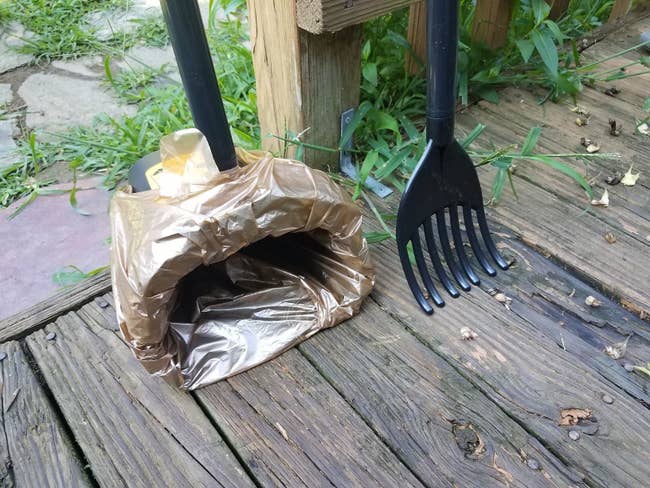 A reviewer's black rake and bin with a yellow box of bags